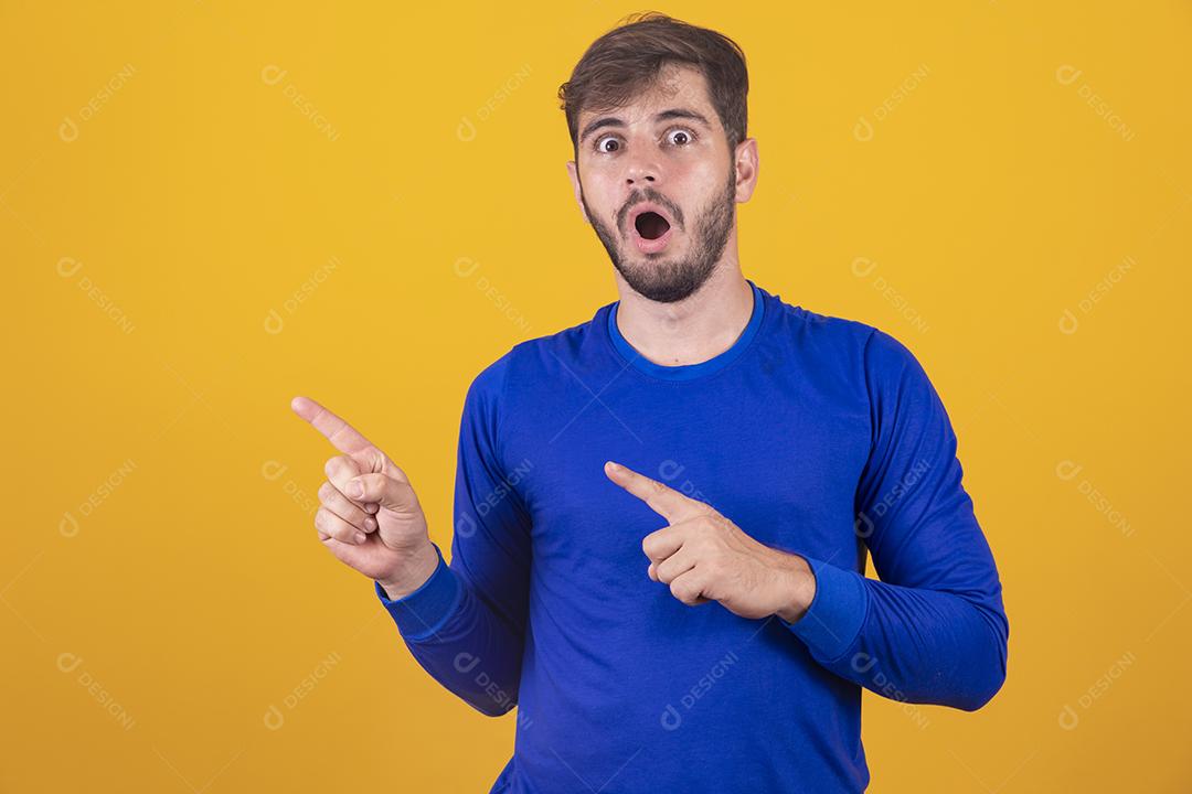 Bonito rapaz expressivo apontando para o lado