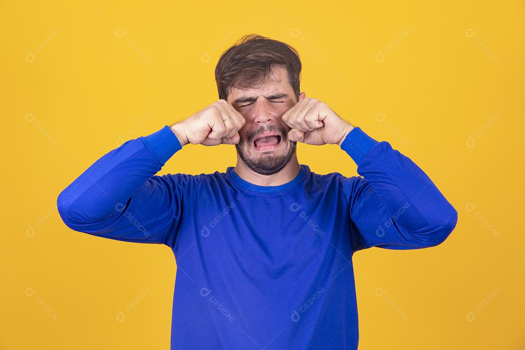 jovem chorando exagerado expressivo sobre fundo amarelo