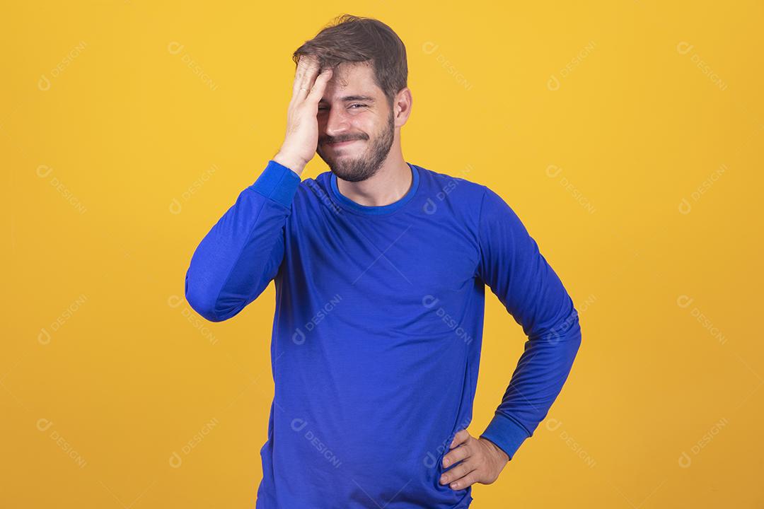 Homem bonito com barba, vestindo camisa azul em fundo amarelo