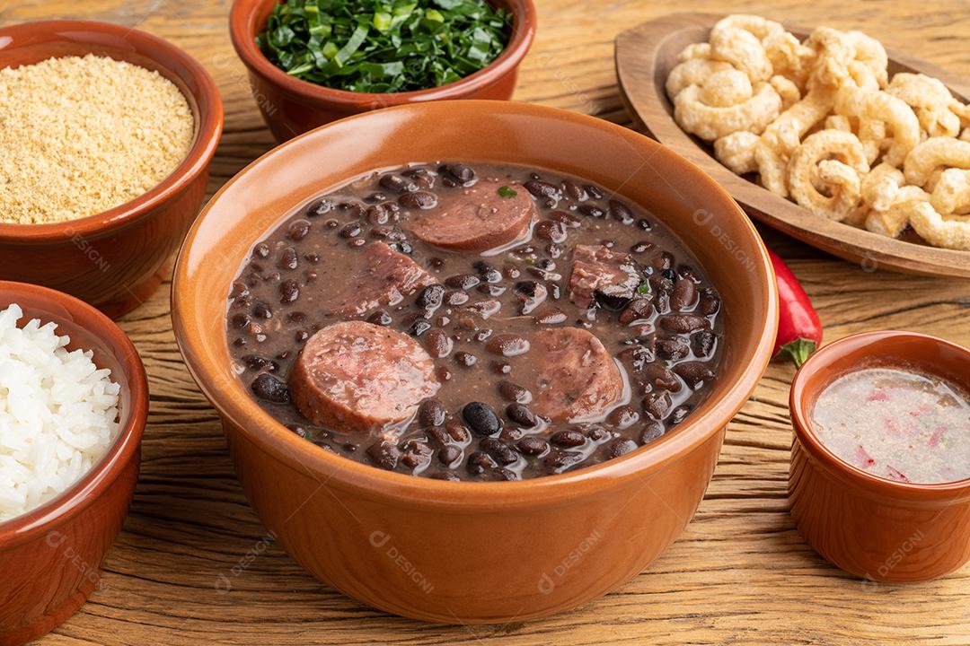Feijoada típica brasileira com arroz, couve, farofa e torresmo.