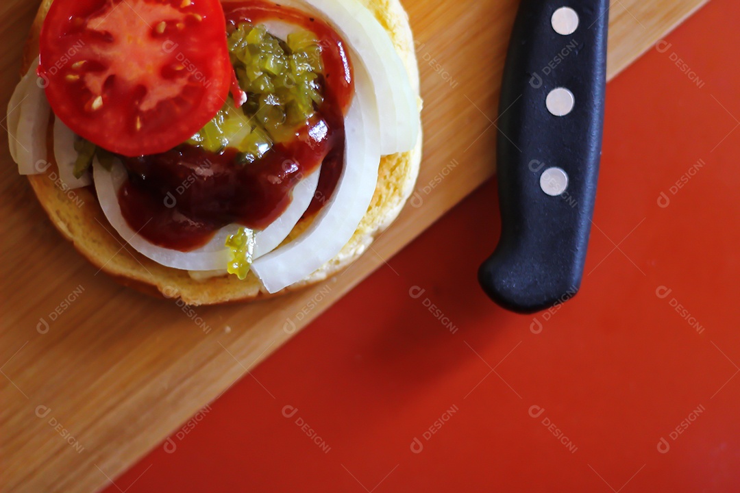 Hambúrgueres estão sendo preparados e servidos em tábuas de madeira, vista superior.