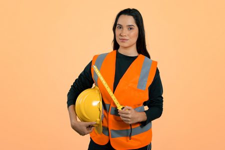 Mulher engenheira de colete refletivo laranja segurando seu capacete amarelo