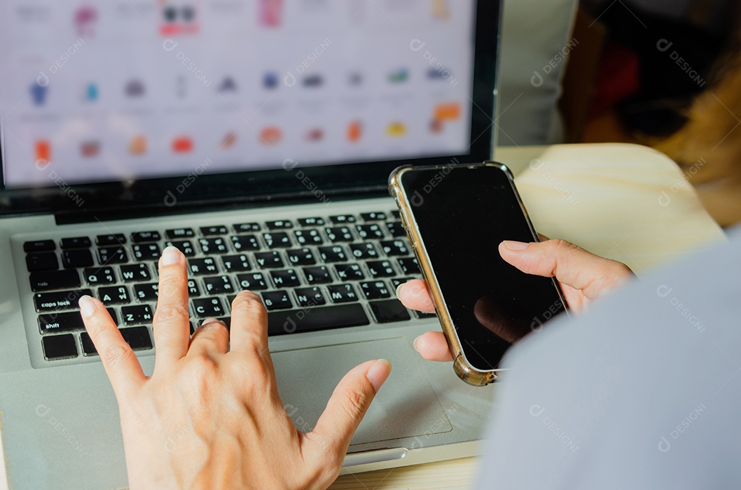 mãos de mulher segurando um telefone inteligente para compras on-line em casa.