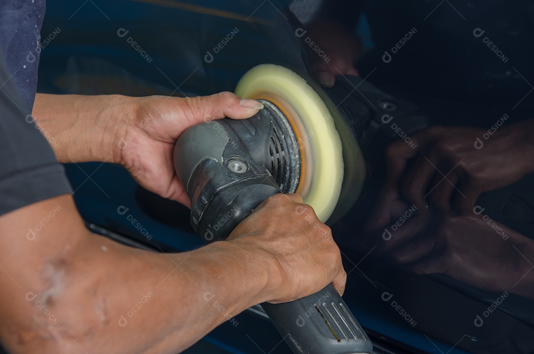 Homem trabalhando para polir, revestir carros.