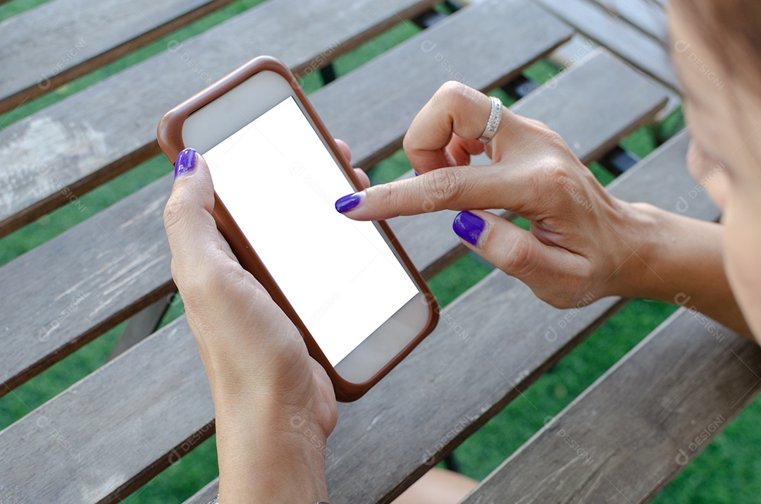 Mulher segurando o telefone inteligente com tela em branco do desktop.