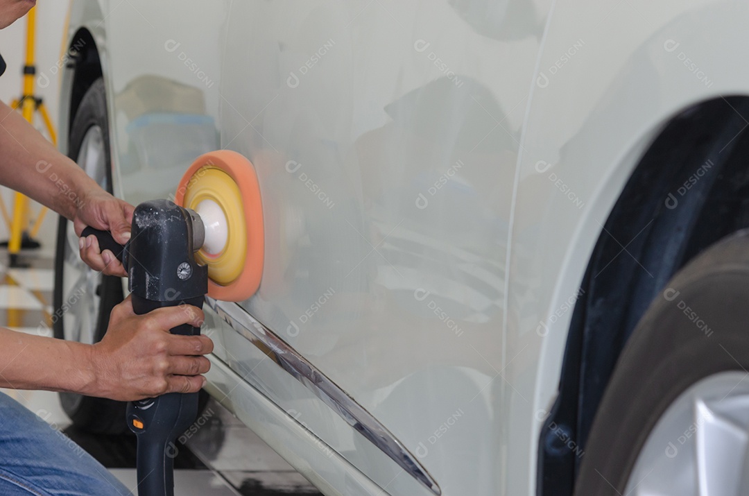 Homem trabalhando para polir, revestir carros.