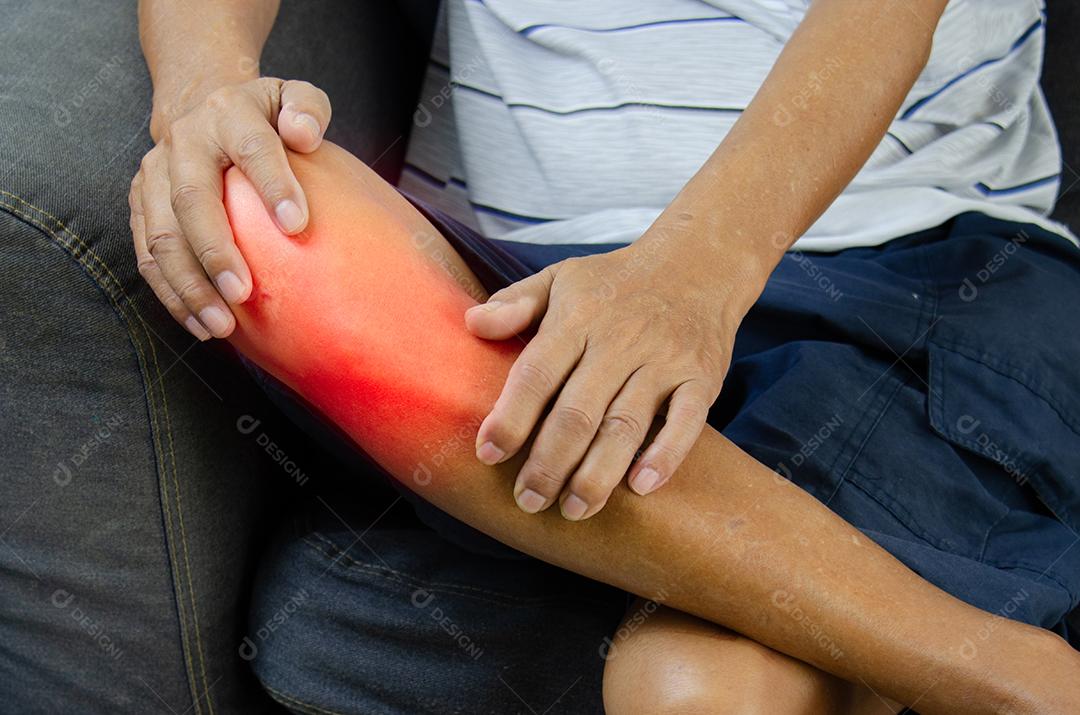 Lesão ou dor no joelho de um homem idoso no sofá.