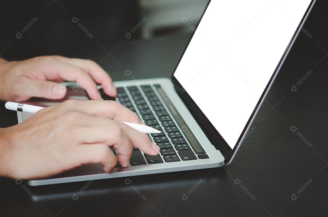 Empresário usando e digitando no laptop com tela branca