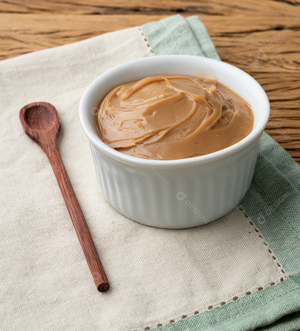 Doce de leite, doce de leite cremoso tradicional brasileiro sobre mesa de madeira.