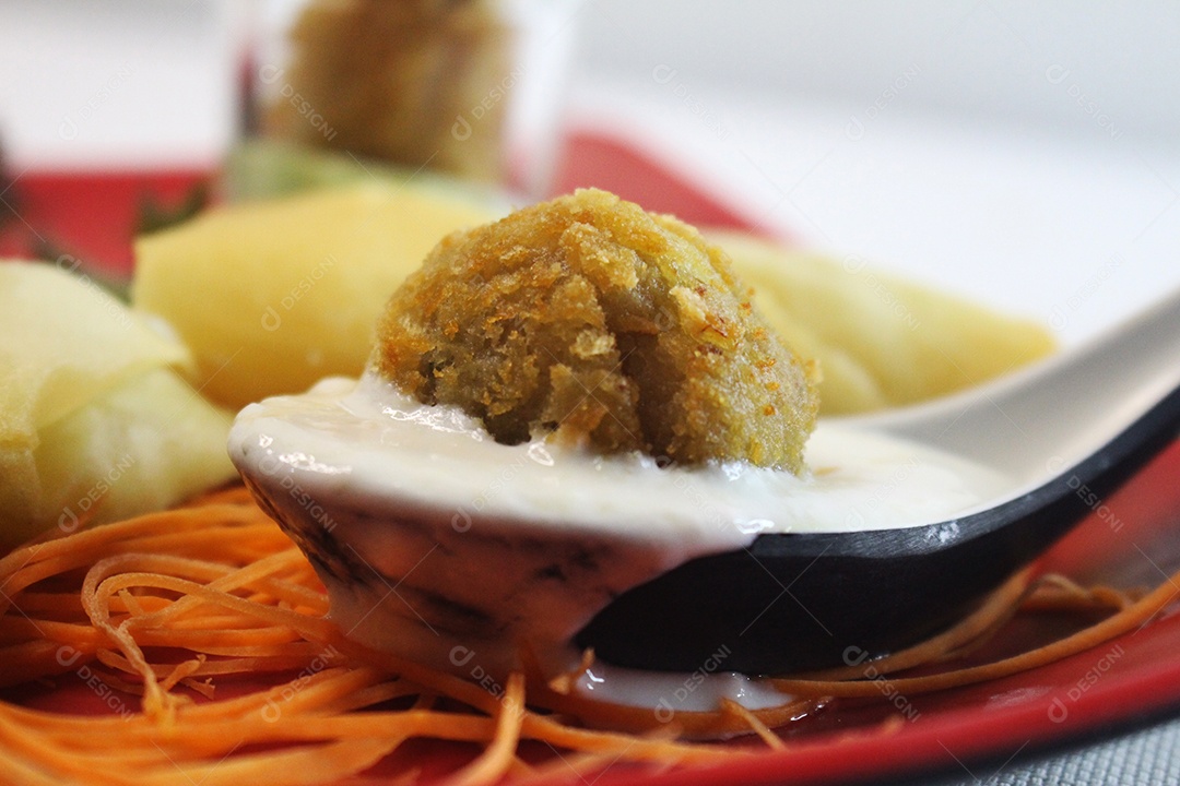 Fotografia de colher com molho e comida japonesa
