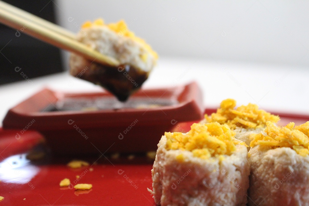 Hashi pegando delecioso sushi comida japonesa e mergulhando em molho