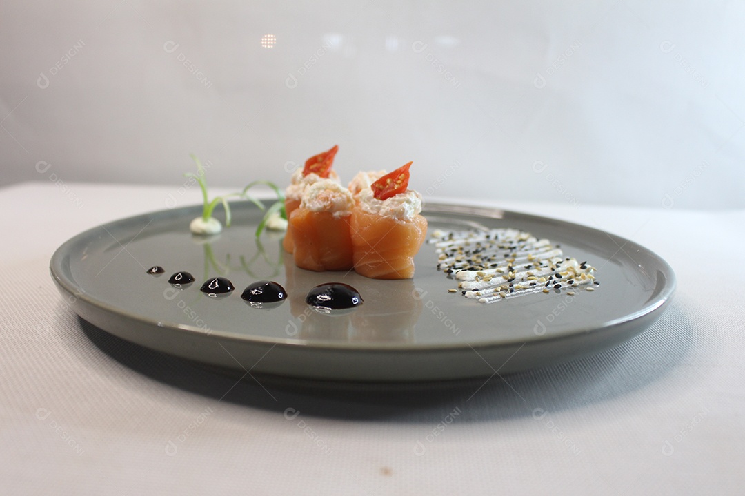 Comida japonesa servida em bandeja com gotas de molho