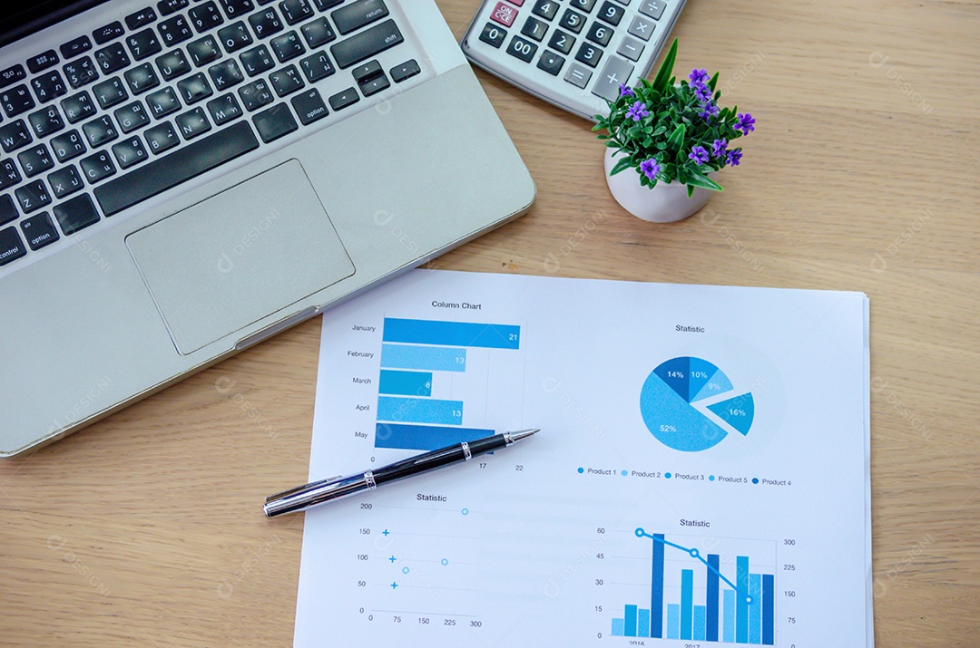 Relatórios de gráficos de negócios, caneta e computador portátil em cima da mesa.