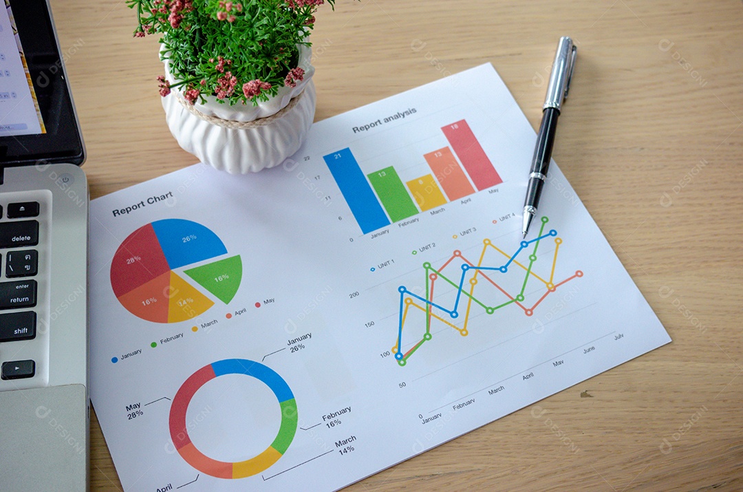 relatórios de gráficos de negócios, caneta e computador portátil em cima da mesa.