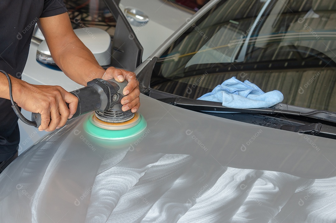 Homem trabalhando para polir, revestir carros.