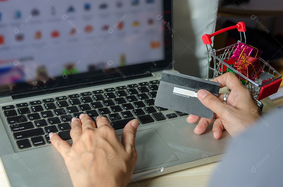 mãos de mulher asiática segurando cartão de crédito e telefone inteligente para compras online em casa.