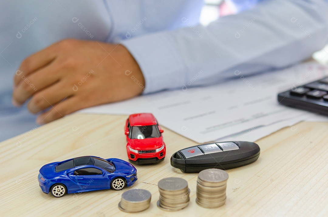 Calculadora de finanças de modelo de carro de brinquedo, chaves de carro e papéis na mesa conceito de seguro de carro