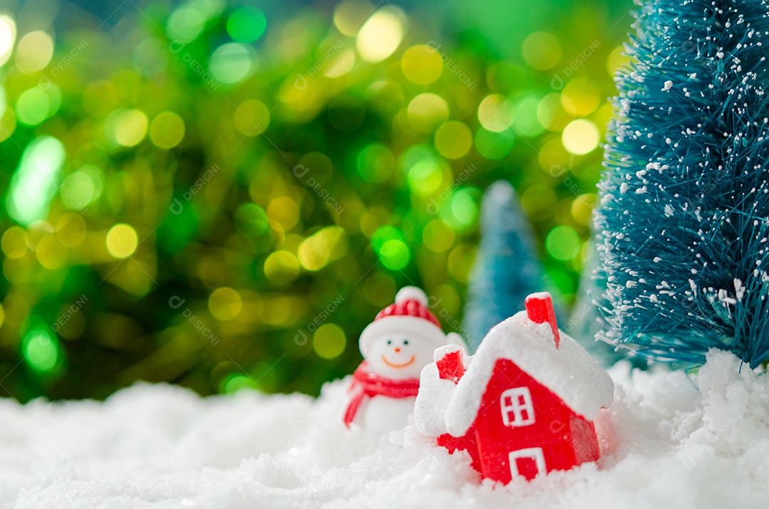 Casa vermelha e árvore de Natal na neve com bokeh de fundo.