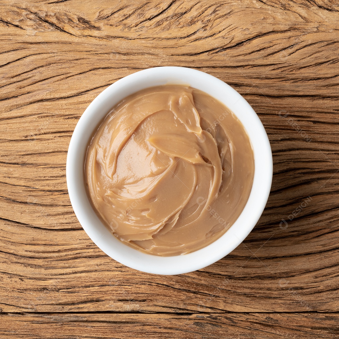 Doce de leite, doce de leite cremoso tradicional brasileiro sobre mesa de madeira.