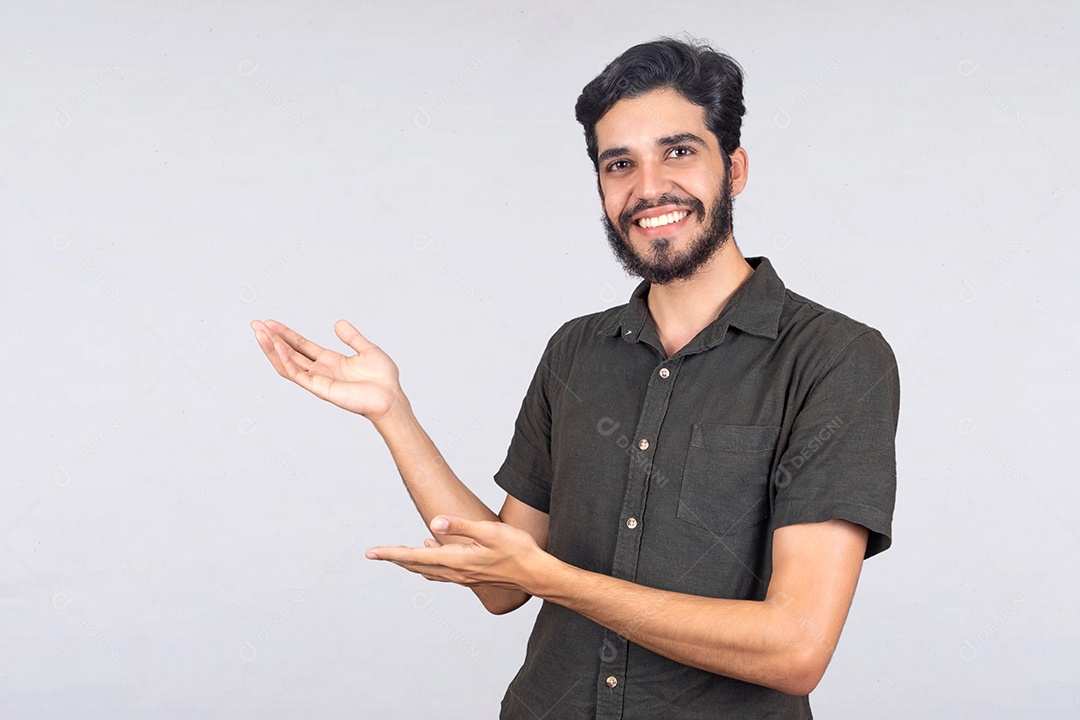 Jovem rapaz sorridente de camiseta cinza com às mão estendida para o lado apresentando produto