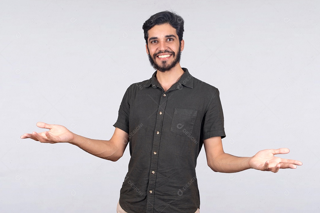 Jovem rapaz sorridente de camiseta cinza fazendo gesto de dúvida