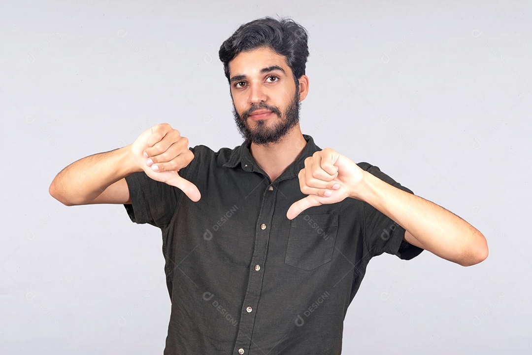 Jovem rapaz de camiseta cinza com polegares para baixo gesto negativo