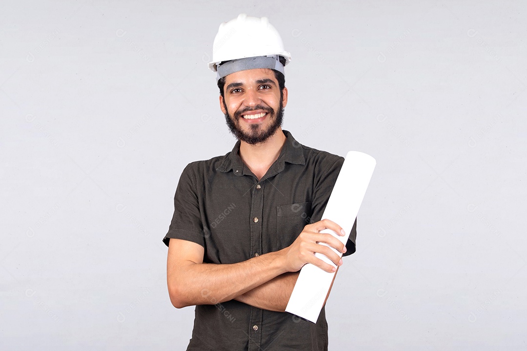 Jovem engenheiro de camiseta cinza com os braços cruzado segurando projeto