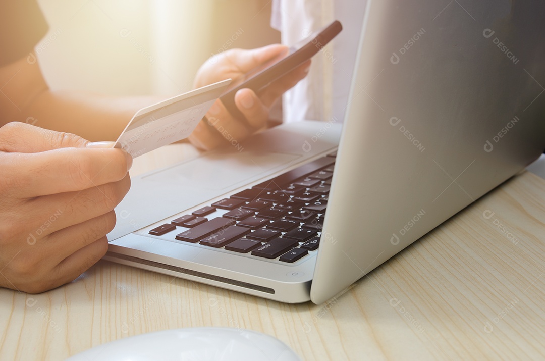 Homem compras on-line usando laptop com cartão de crédito