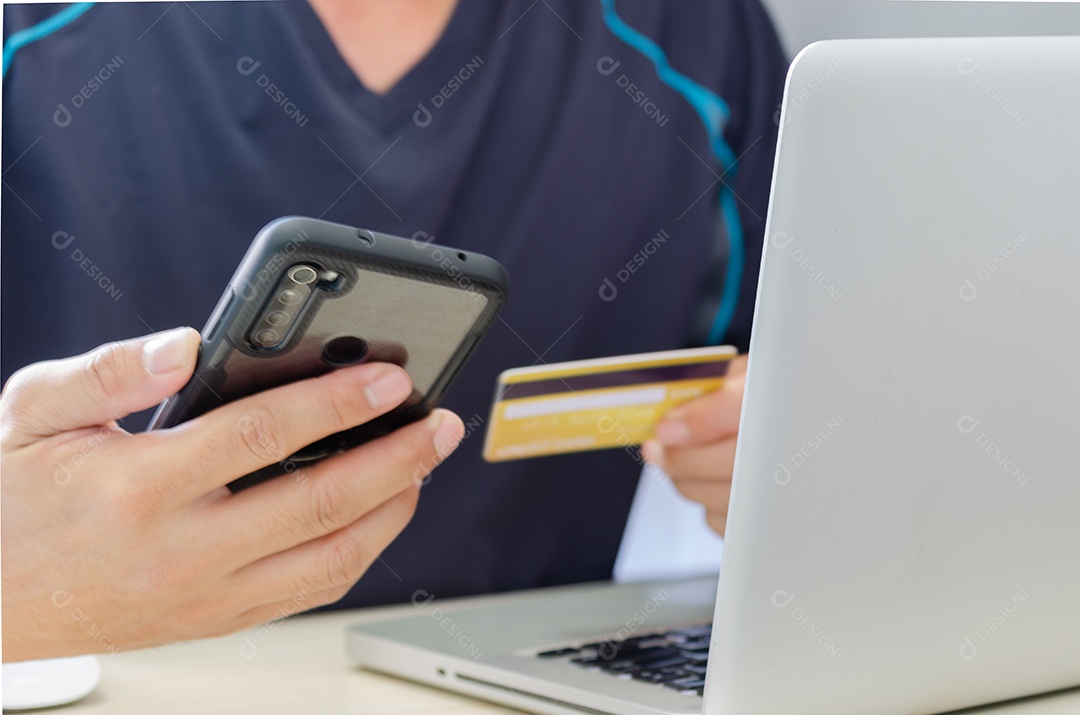 Homem fazendo compras on-line usando laptop com cartão de crédito