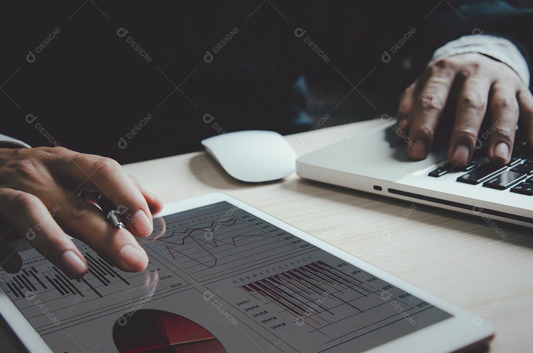 Empresário analisando gráficos e gráficos relatam estatísticas de lucro e crescimento em tablets.