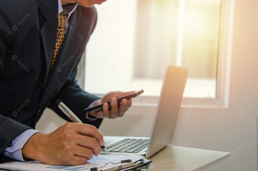 Homem de negócios segurando uma caneta, documentos comerciais, relatórios, gráficos e tabelas de demonstrações financeiras e crescimento do lucro