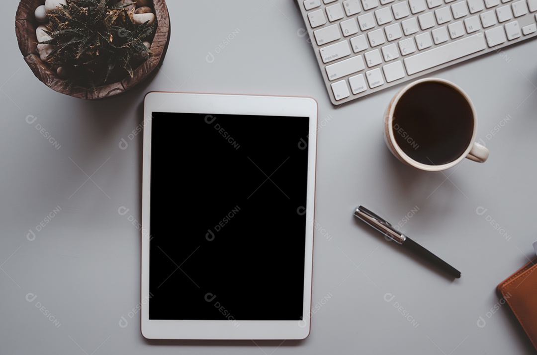 Mesa de escritório com teclado, computador, tablet, caneta, café e cacto em fundo cinza tom vintage. Vista superior com espaço de cópia. Conceito de negócios e finanças