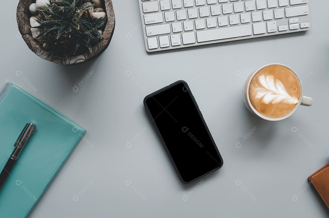 Mesa de escritório com teclado, computador, smartphone, notebook, café e cacto em fundo cinza tom vintage. Vista superior com espaço de cópia. Conceito de negócios e finanças