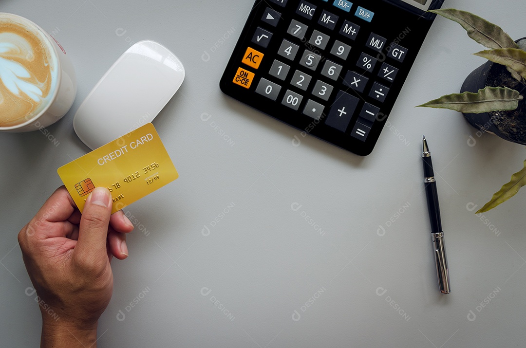 Vista superior mão calculadora de cartão de crédito e caneca de café cacto na mesa.