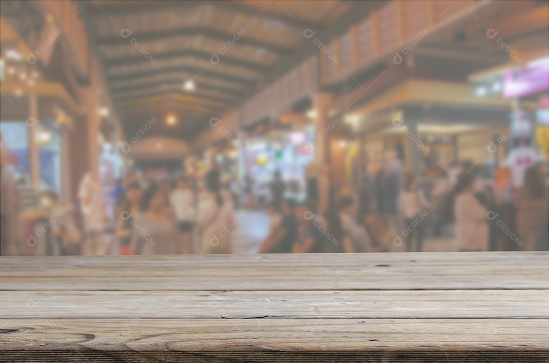 Tampo da mesa de madeira e pessoas de imagem desfocada abstrata andando no mercado noturno andando pela rua. Pode ser usado para exibição
