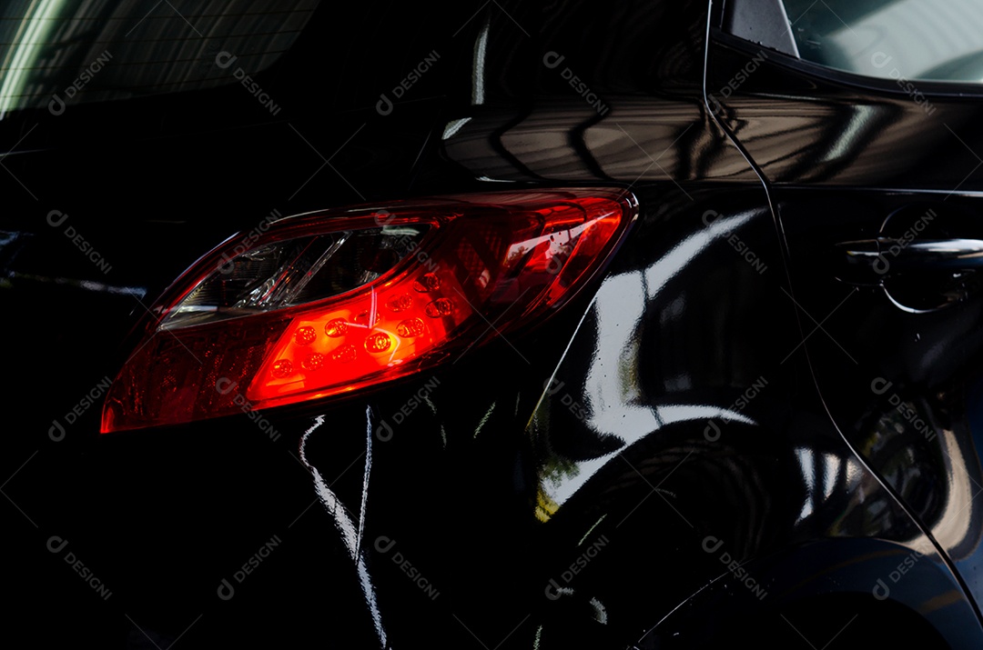 Luz traseira do carro de luxo em um fundo preto.