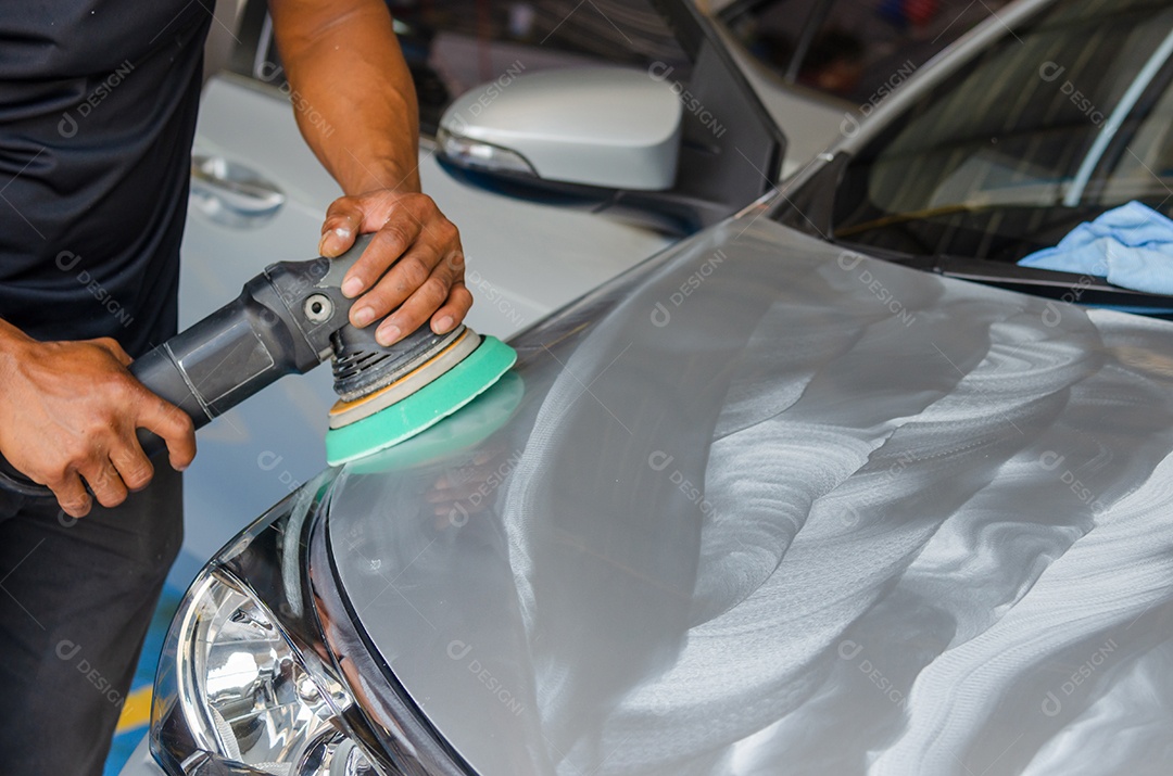 Mãos com polidor de máquina em reparação de automóveis.