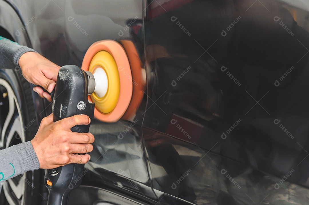 Mão de mecânico segurando o polonês do carro