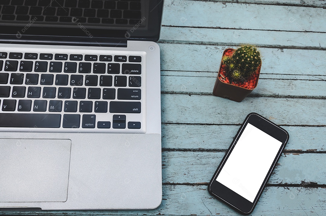 Laptop e smartphone e cacto em uma mesa de madeira. Tom vintage