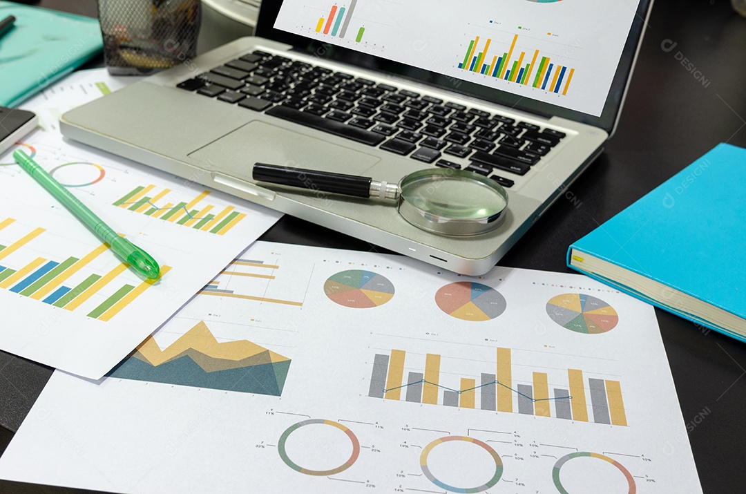 Documentos de negócios gráficos financeiros, análise estatística na mesa com computador portátil.