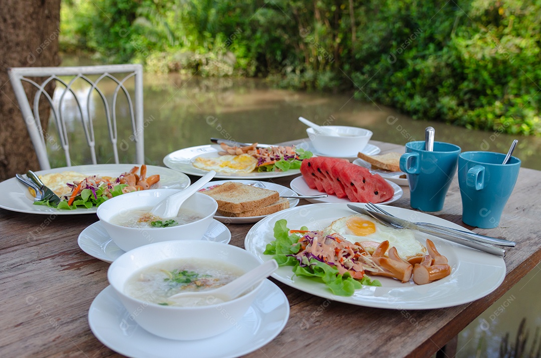 Café da manhã na mesa, pão, ovo frito, salsicha no rio