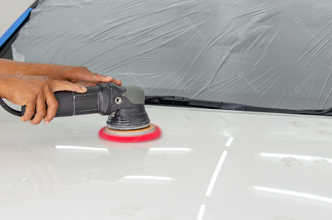 Homem trabalhando para polir, revestir carros.