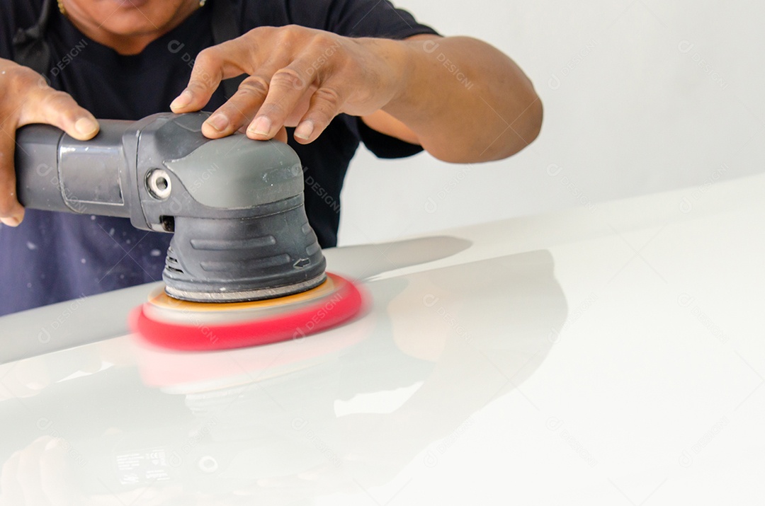 Homem trabalhando para polir, revestir carros.