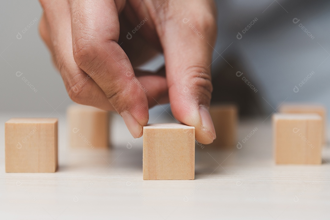 Mão segurando o bloco de cubo de madeira. Conceito de sucesso de crescimento do negócio.