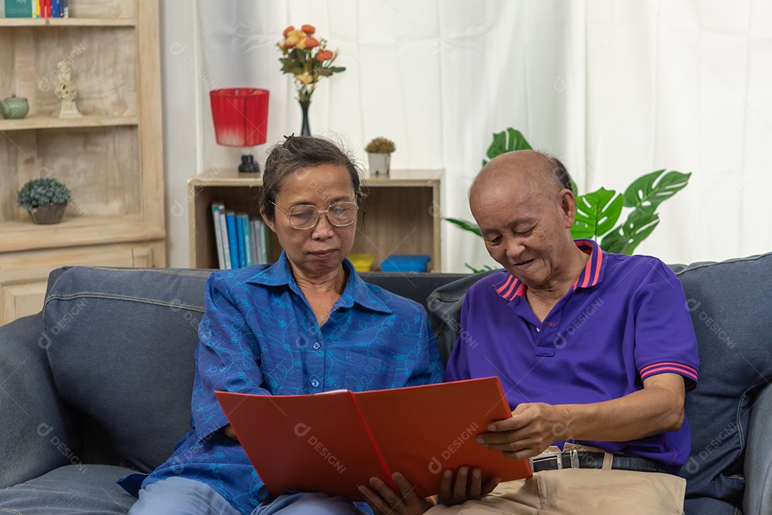 Casal asiático sênior falando feliz plano de seguro de aposentadoria contrato de saúde no sofá.