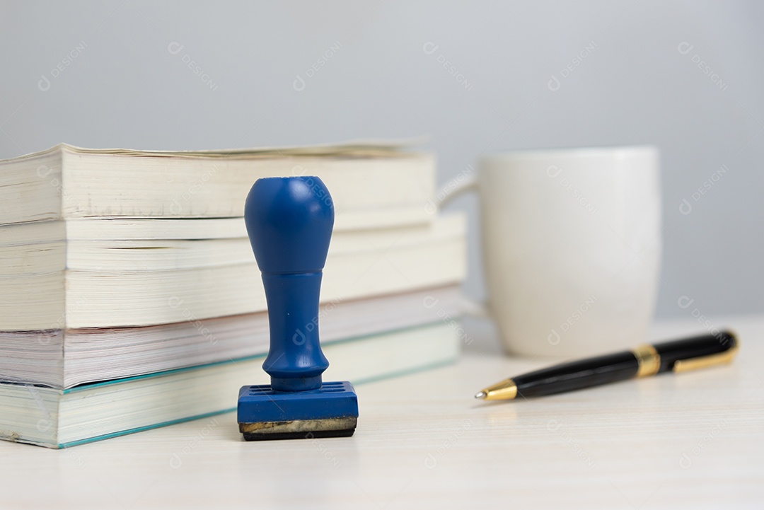 Livro e carimbo de borracha e caneta na mesa no escritório Conceito de negócios.