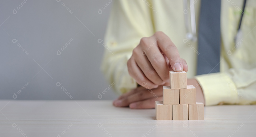 Médico de mão segurando o bloco de cubo de madeira. Fundo de panorama de conceito de sucesso de crescimento de negócios.