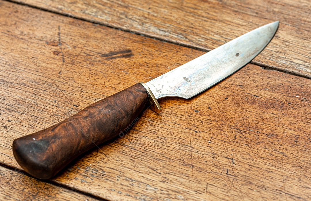 Faca de churrasco vintage com cabo de madeira rústica na mesa de madeira envelhecida.