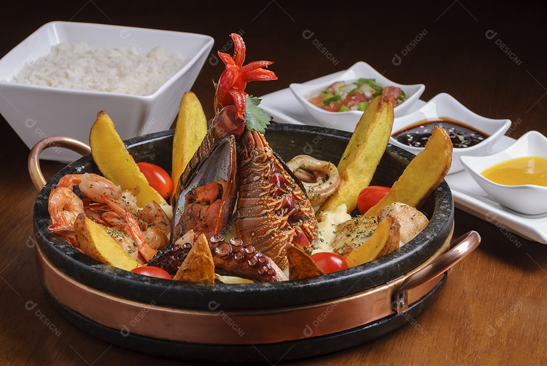Prato com mariscos, com polvo, mexilhões, camarões, lagosta e lulas, acompanhado de batatas, arroz e molhos.