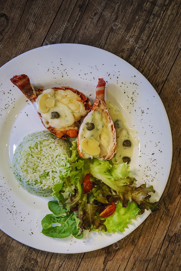 Lagosta com arroz e salada em uma mesa de madeira. Conjunto de mesa de frutos do mar.